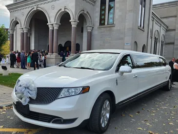 White stretch limousine parked outside a venue